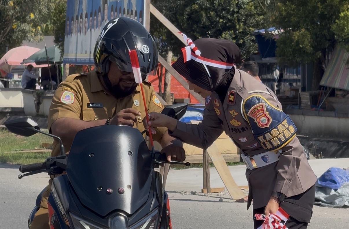 SATLANTAS POLRES HALMAHERA TENGAH BAGIKAN RATUSAN BENDERA MERAH PUTIH KEPADA MASYARAKAT