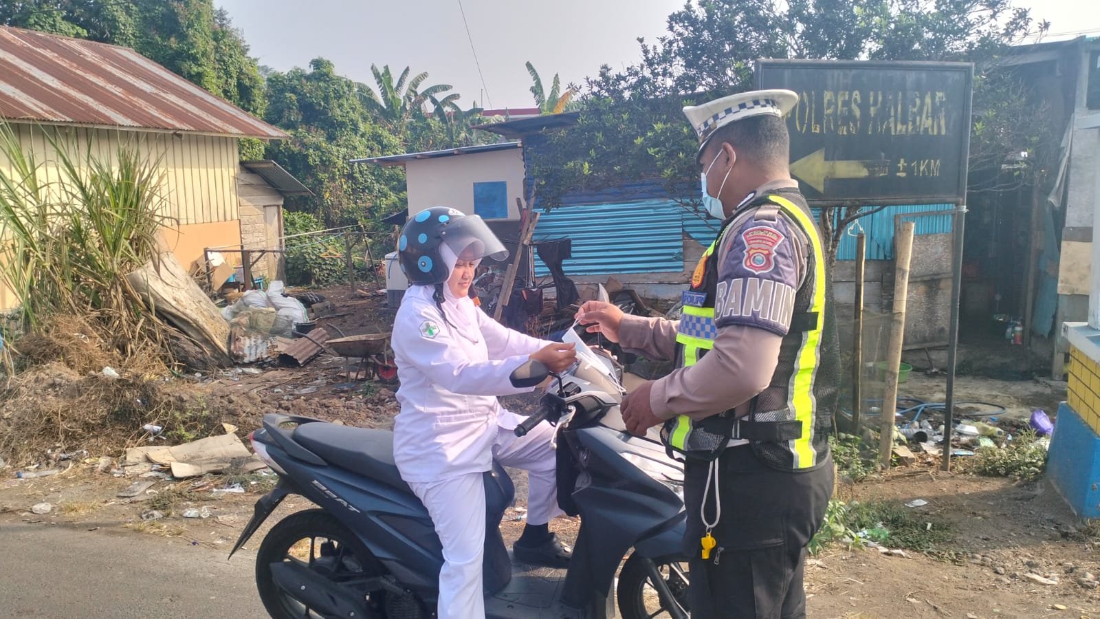 Di Tengah Kabut Asap, Polres Halbar Hadir Membawa Kepedulian Lewat Pembagian Masker